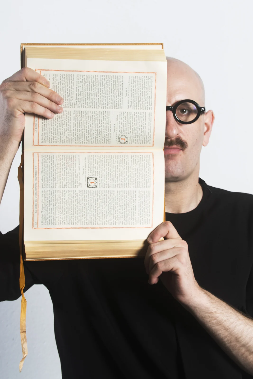 Portrait de Lucas Vuilleumier, le visage à moitié caché par un livre ouvert